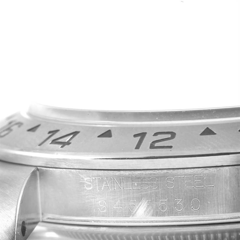 A close-up of the bezel, part of the case, and engraved details of the Rolex Explorer 16570 Men
s Stainless Steel White Dial 16570 Men
s Stainless Steel White Dial watch is shown.