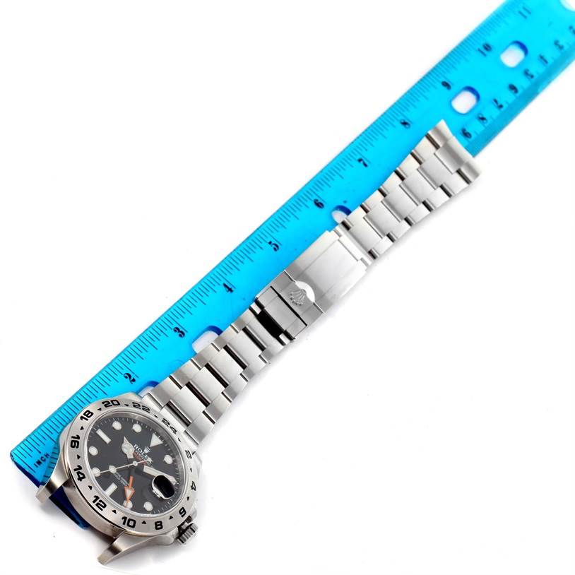 The image shows the full length of a Rolex Explorer 216570 Men
s Stainless Steel Black Dial 216570 Men
s Stainless Steel Black Dial watch placed next to a blue ruler for measurement.