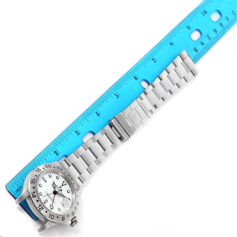 The image shows the Rolex Explorer 16570 Men's Stainless Steel White Dial 16570 Men's Stainless Steel White Dial watch lying flat, with the face and full bracelet visible, next to a blue ruler for measurement.