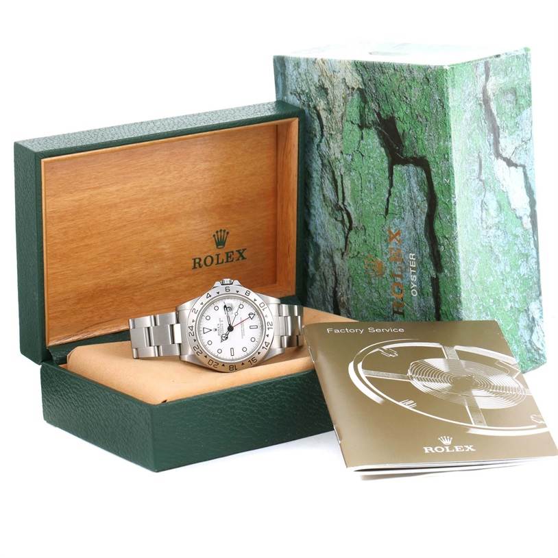The Rolex Explorer 16570 Men's Stainless Steel White Dial 16570 Men's Stainless Steel White Dial watch is shown inside its open green box with a booklet and outer box displayed beside it.