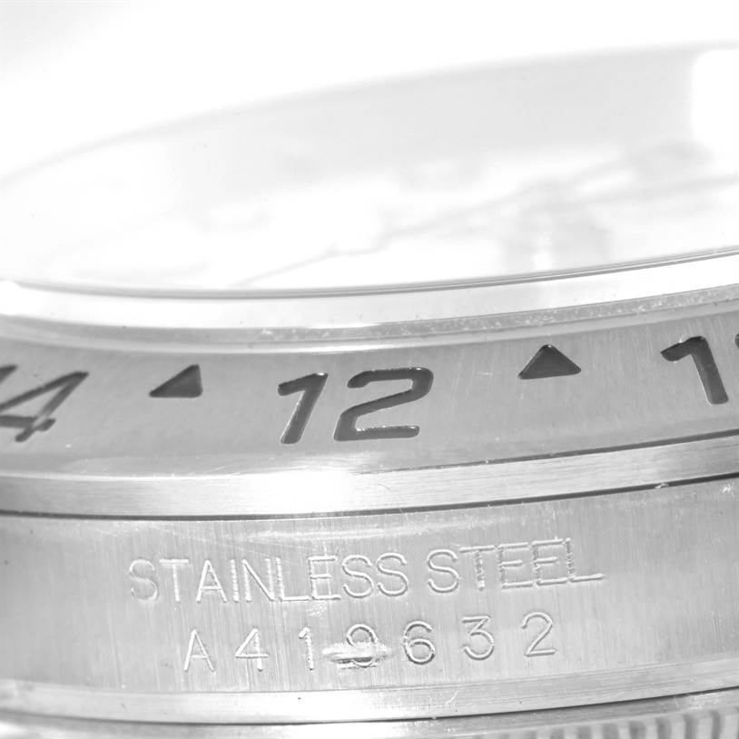 This image shows a close-up angle of the bezel and part of the stainless steel case of a Rolex Explorer 16570 Men's Stainless Steel White Dial 16570 Men's Stainless Steel White Dial watch.