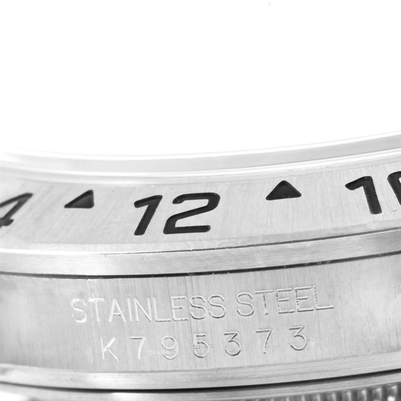 This image shows a close-up of the bezel and part of the case back of a Rolex Explorer 16570 Men's Stainless Steel White Dial 16570 Men's Stainless Steel White Dial model, with a focus on the engraved details.
