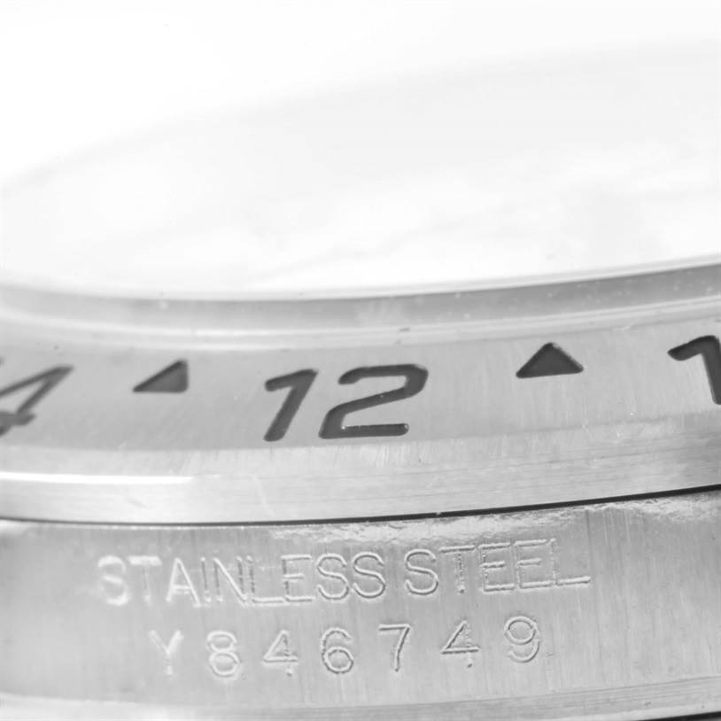 The image shows a close-up of the bezel and part of the case of a Rolex Explorer 16570 Men's Stainless Steel White Dial 16570 Men's Stainless Steel White Dial watch, highlighting the "stainless steel" engraving.