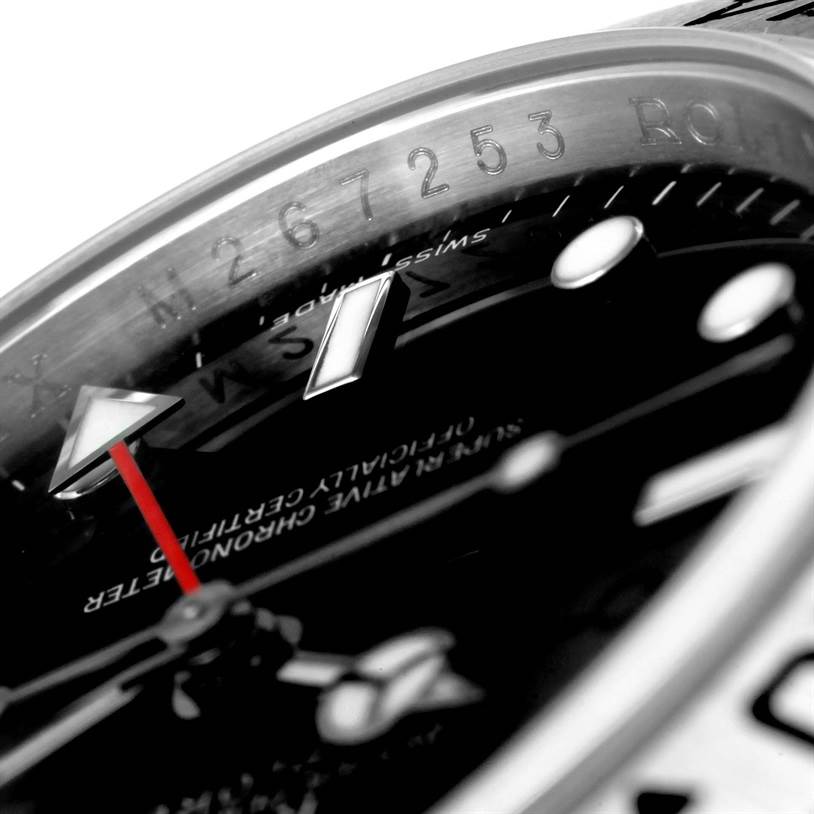 This close-up angle of a Rolex Explorer 16570 Men's Stainless Steel Black Dial 16570 Men's Stainless Steel Black Dial watch shows the bezel, part of the black dial, and the red second hand.
