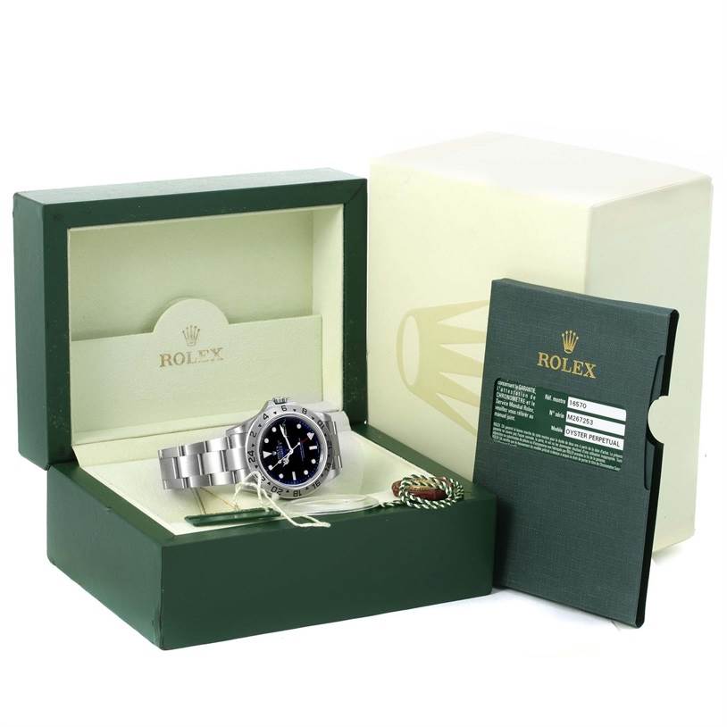 The image shows a Rolex Explorer 16570 Men's Stainless Steel Black Dial 16570 Men's Stainless Steel Black Dial watch in its open box, along with warranty card and accessories, displayed from the front.