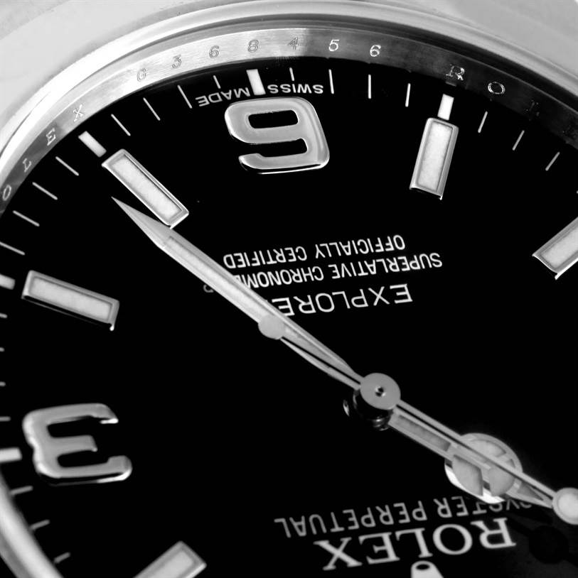 The image shows a close-up of the dial and hands of the Rolex Explorer 214270 Men's Stainless Steel Black Dial 214270 Men's Stainless Steel Black Dial watch, including indices and part of the bezel.