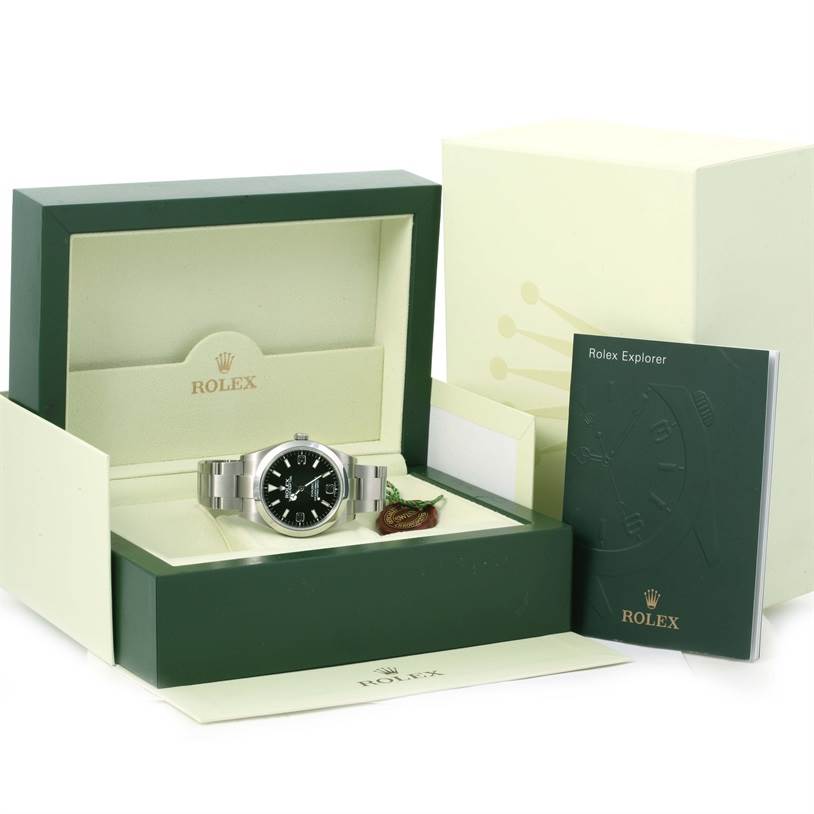The Rolex Explorer 214270 Men's Stainless Steel Black Dial 214270 Men's Stainless Steel Black Dial watch is displayed face-up in an open green box with accompanying booklet and accessories.