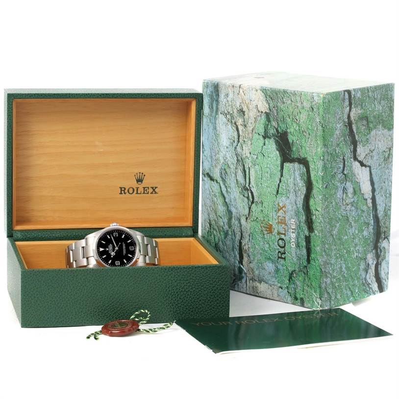 The Rolex Explorer 114270 Men's Stainless Steel Black Dial 114270 Men's Stainless Steel Black Dial watch is displayed open in its box with the outer box and booklet beside it.