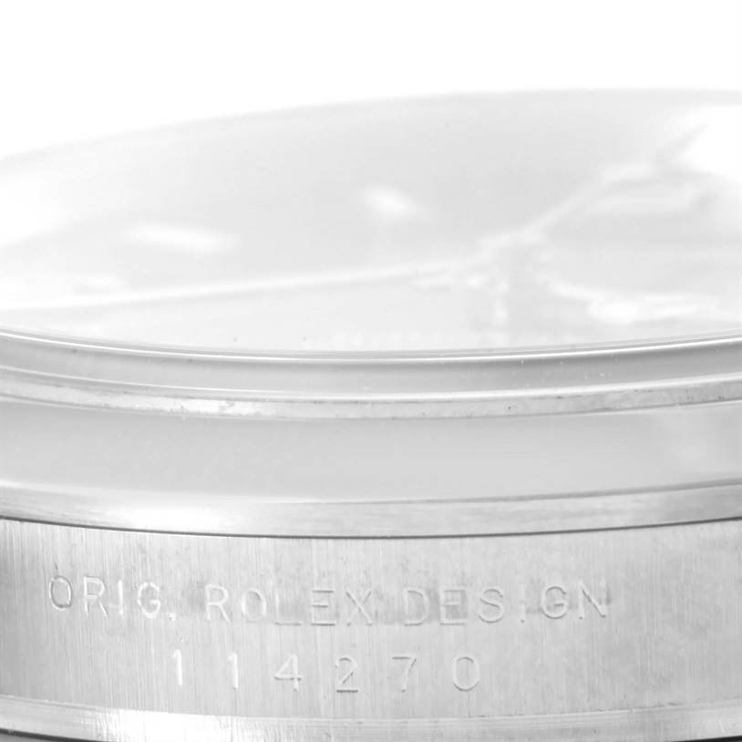 The image shows a close-up side view of the case of a Rolex Explorer 114270 Men's Stainless Steel Black Dial 114270 Men's Stainless Steel Black Dial watch, highlighting its serial number.