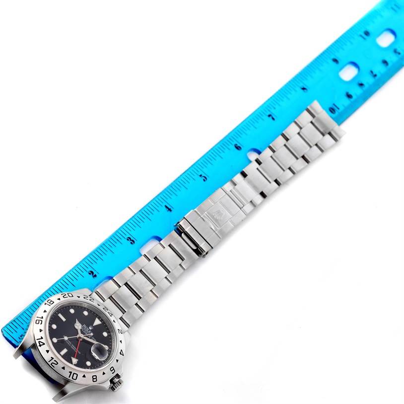 The image shows the Rolex Explorer 16570 Men's Stainless Steel Black Dial 16570 Men's Stainless Steel Black Dial watch lying flat, with the face, bezel, and full metal bracelet visible, aligned with a ruler.