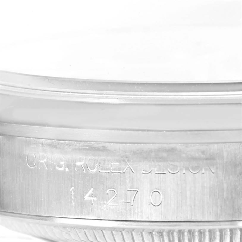 The image shows a close-up of the side of the Rolex Explorer 14270 Men's Stainless Steel Black Dial 14270 Men's Stainless Steel Black Dial watch model, focusing on the engraved serial and design numbers.