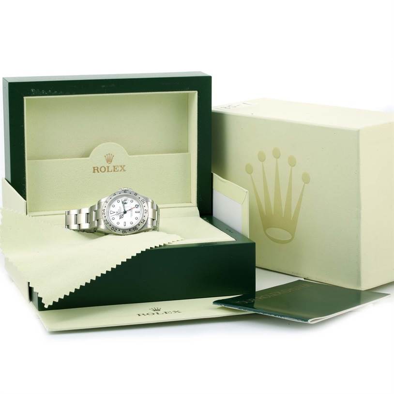 The image shows a Rolex Explorer 16570 Men's Stainless Steel White Dial 16570 Men's Stainless Steel White Dial watch in its green and beige box with cleaning cloths and manuals.