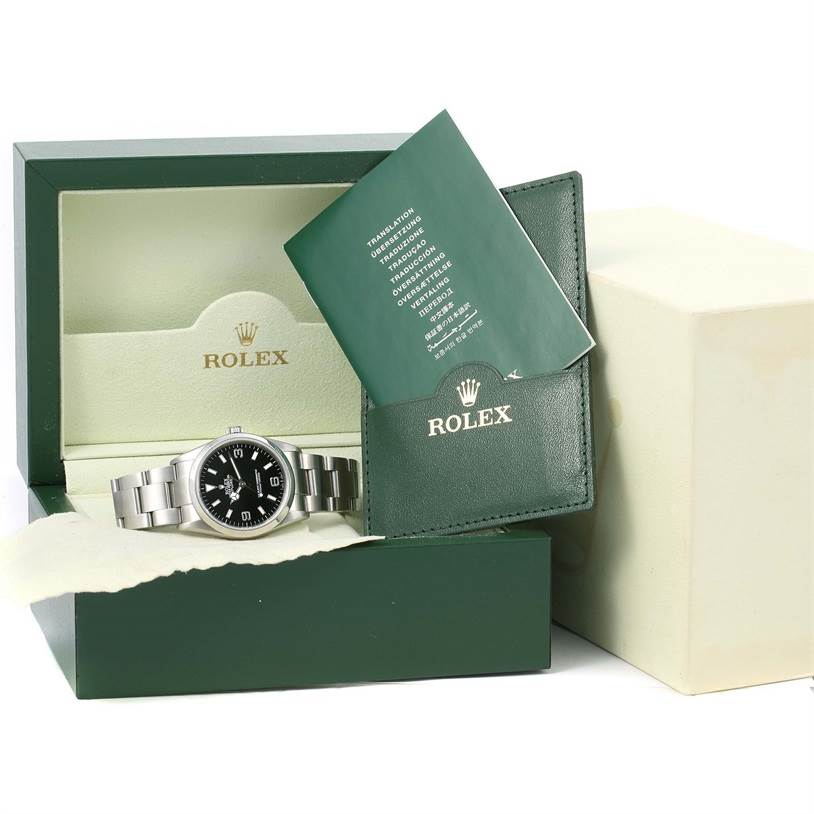 The image shows a Rolex Explorer 114270 Men's Stainless Steel Black Dial 114270 Men's Stainless Steel Black Dial watch in an open box with documentation and accessories displayed.