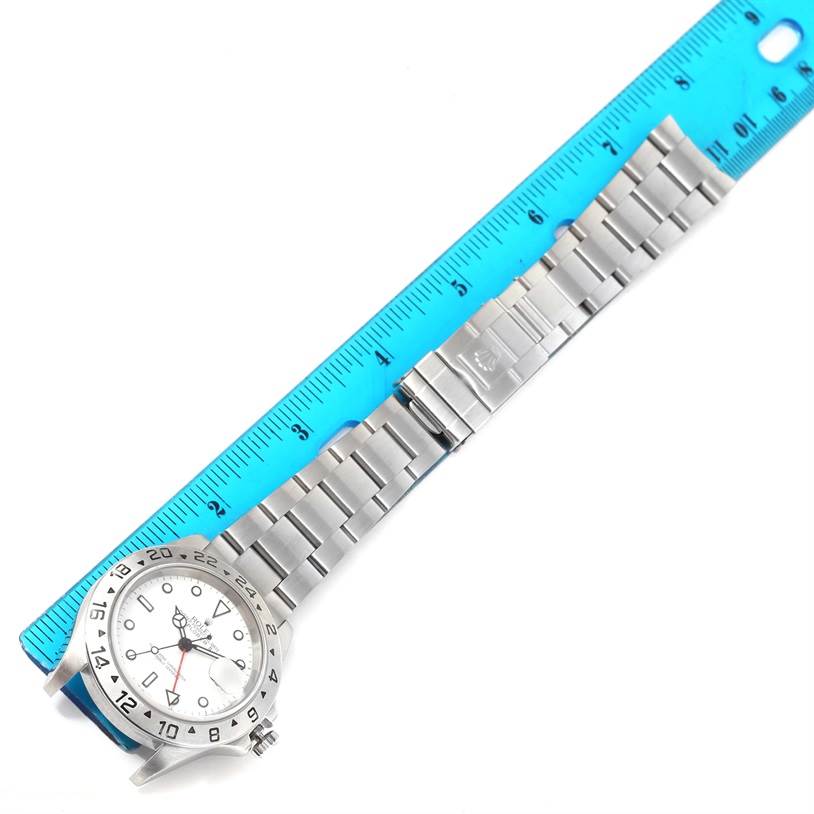 The image shows a Rolex Explorer 16570 Men's Stainless Steel White Dial 16570 Men's Stainless Steel White Dial watch, including the face, case, and full bracelet, placed next to a blue ruler for scale.