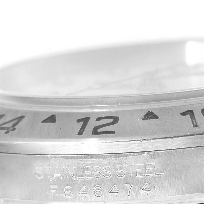 The image shows a close-up of the bezel and case with the serial number etched on a Rolex Explorer 16570 Men's Stainless Steel White Dial 16570 Men's Stainless Steel White Dial model.