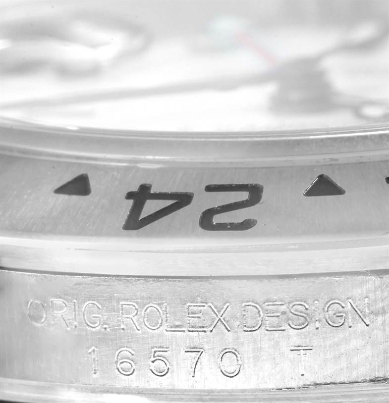 The image shows a close-up of the bezel and case side of a Rolex Explorer 16570 Men's Stainless Steel White Dial 16570 Men's Stainless Steel White Dial model 16570, with inscription details visible.