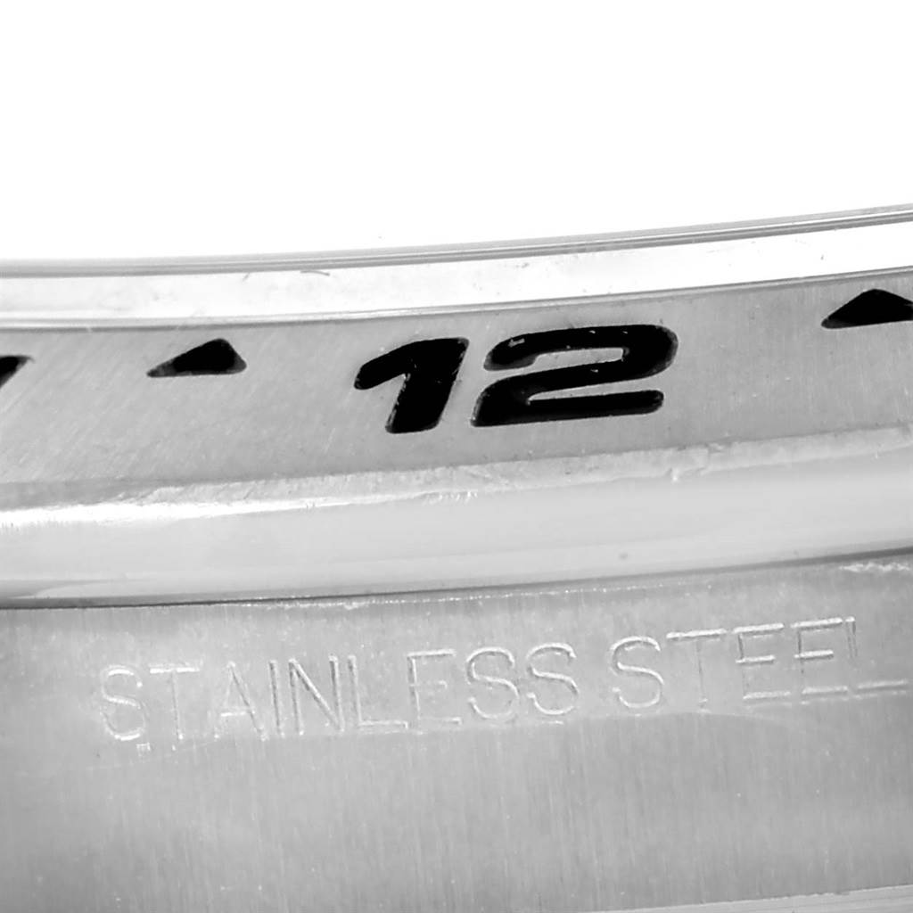 The image shows a close-up of the bezel and part of the case of a stainless steel Rolex Explorer 216570 Men's Stainless Steel White Dial 216570 Men's Stainless Steel White Dial watch.