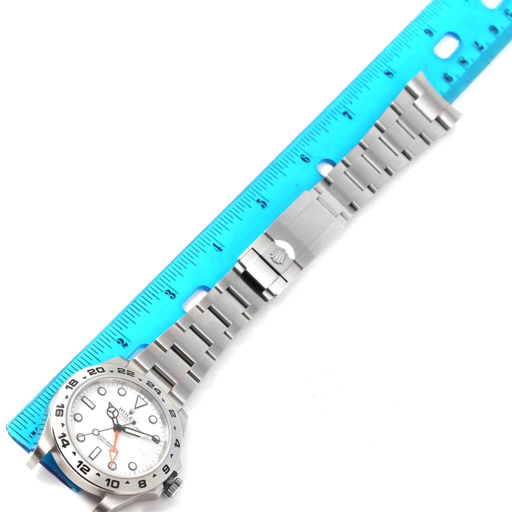 This image shows the complete Rolex Explorer 216570 Men
s Stainless Steel White Dial 216570 Men
s Stainless Steel White Dial watch laid flat with a blue ruler for scale.
