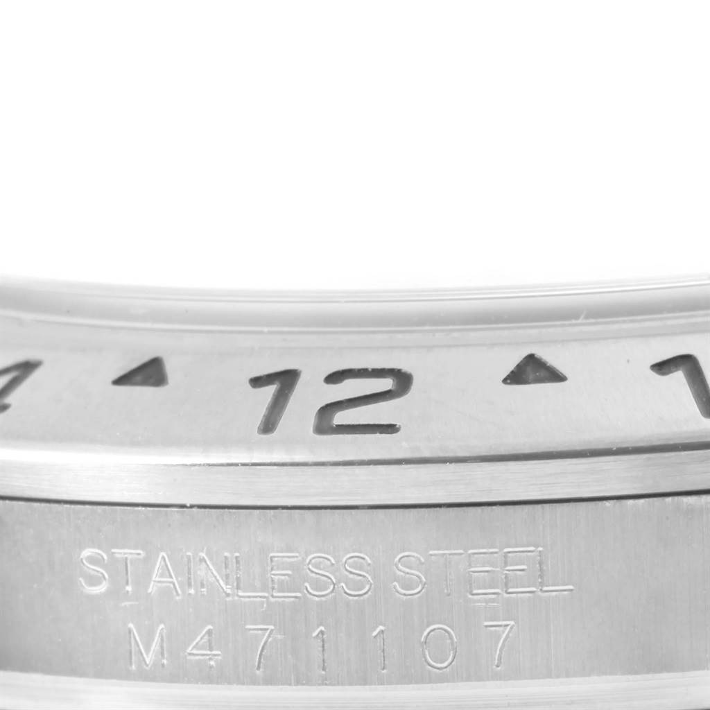 This close-up image shows the engraved bezel and stainless steel part of the Rolex Explorer 16570 Men's Stainless Steel White Dial 16570 Men's Stainless Steel White Dial model watch.