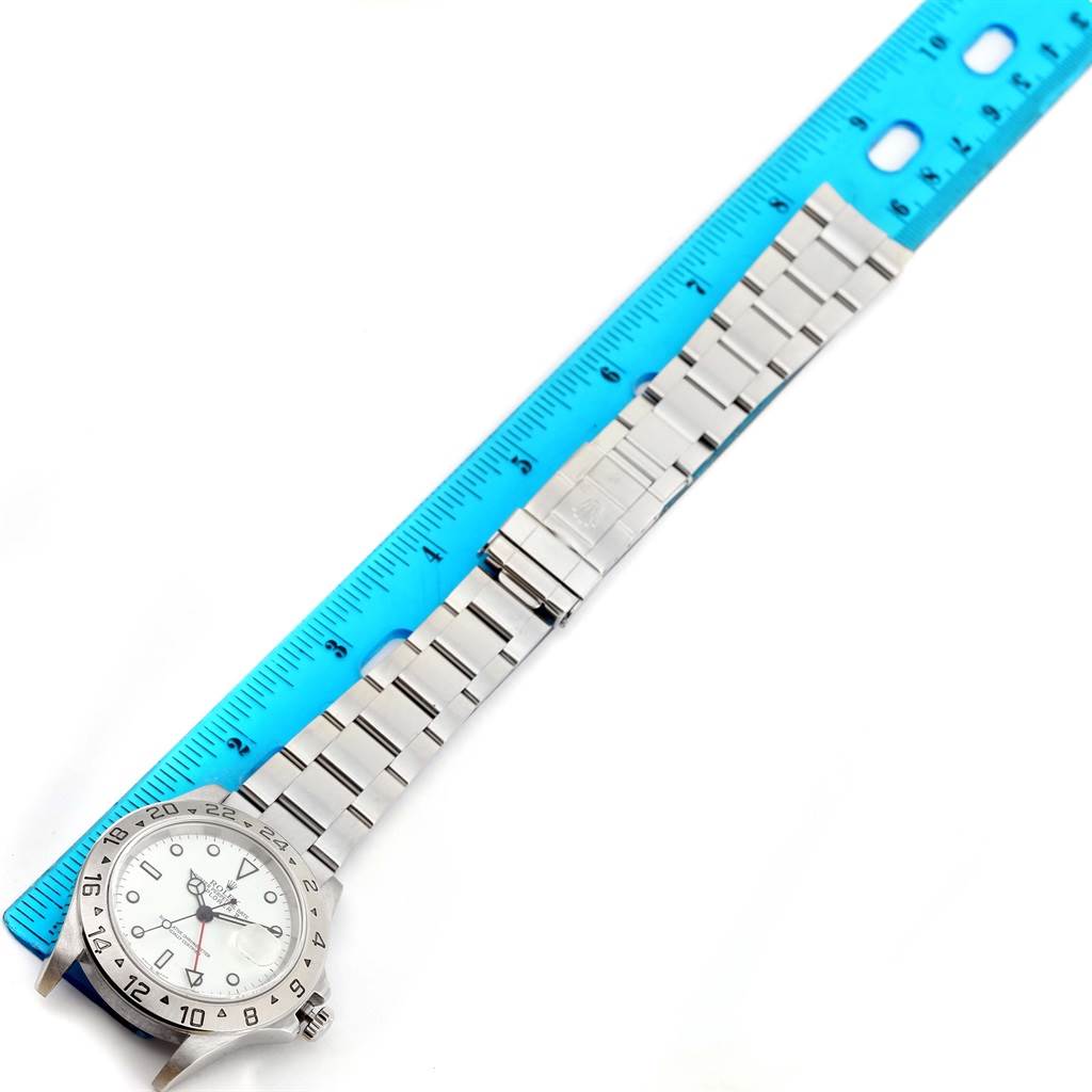 The image shows a Rolex Explorer 16570 Men's Stainless Steel White Dial 16570 Men's Stainless Steel White Dial watch positioned next to a blue ruler, displaying the face, bezel, and entire bracelet.