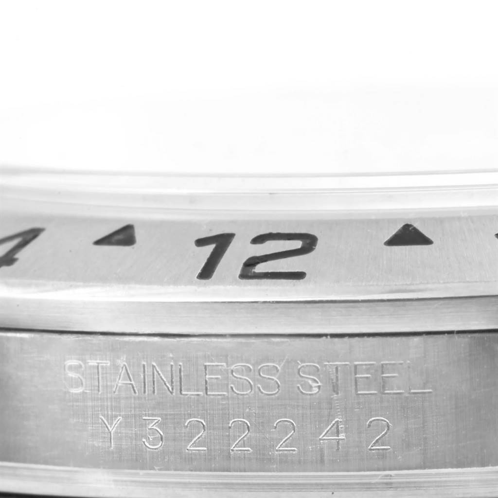 This image shows a close-up of the bezel and case of the Rolex Explorer 16570 Men's Stainless Steel Black Dial 16570 Men's Stainless Steel Black Dial, highlighting the serial number and word "STAINLESS STEEL."