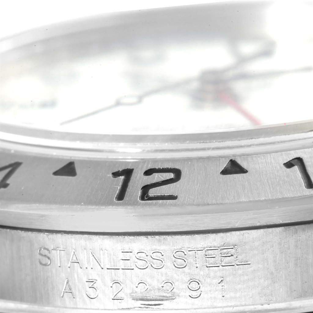 This image shows a close-up of the bezel and case of a Rolex Explorer 16570 Men's Stainless Steel White Dial 16570 Men's Stainless Steel White Dial watch, highlighting the "12" marker and the "Stainless Steel" engraving.