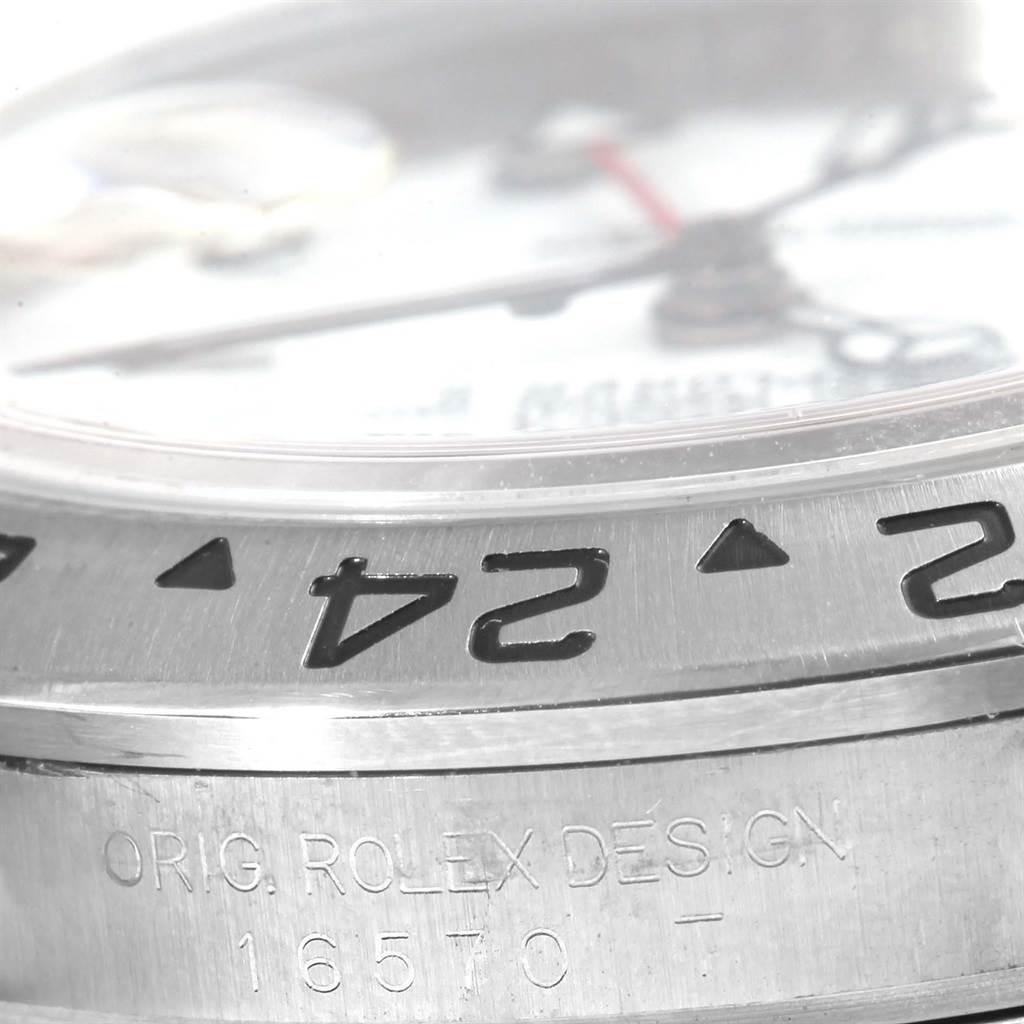 The image shows a close-up of the bezel and part of the dial of a Rolex Explorer 16570 Men's Stainless Steel White Dial 16570 Men's Stainless Steel White Dial watch.
