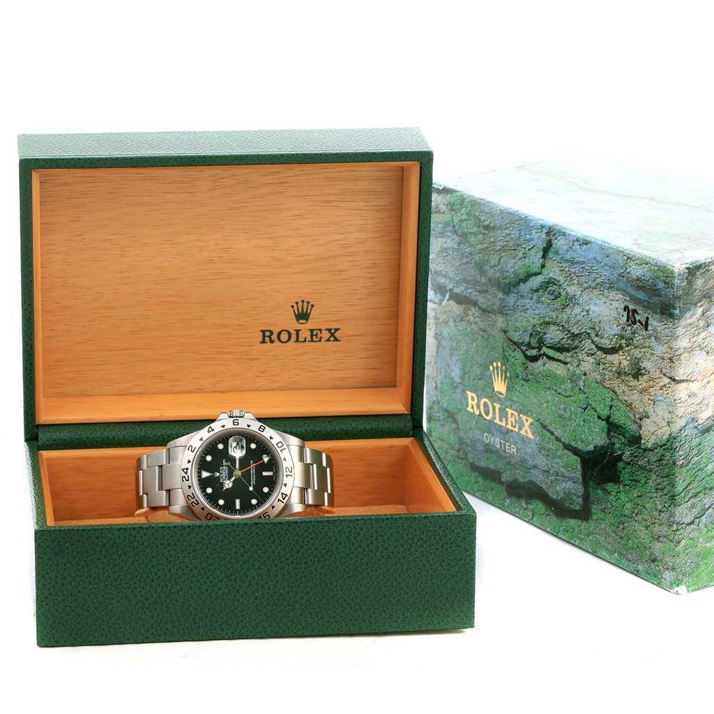 This image shows a Rolex Explorer 16570 Men's Stainless Steel Black Dial 16570 Men's Stainless Steel Black Dial watch placed inside an open green and wooden Rolex box, with the outer box beside it.