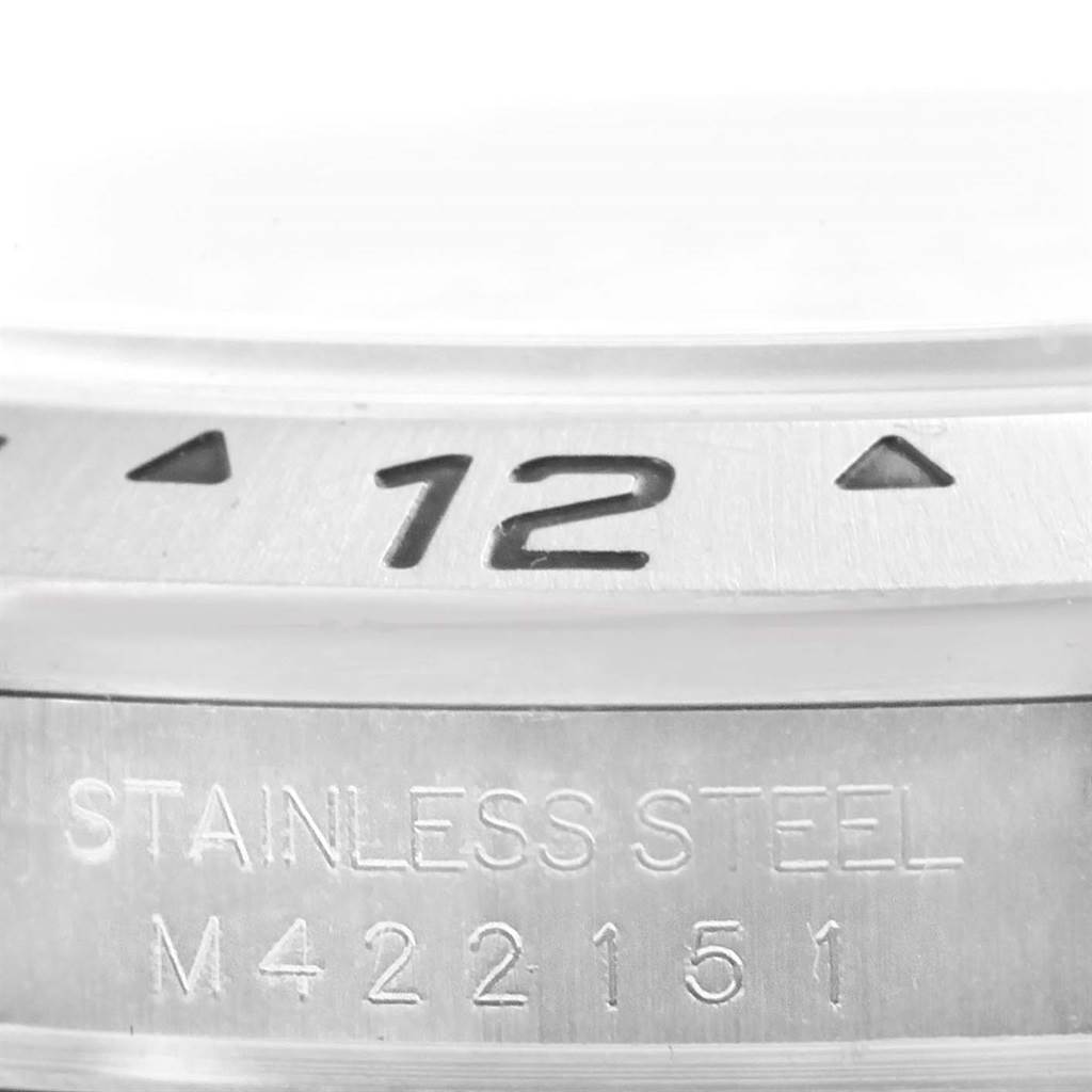 This image shows a close-up of the bezel and case of a Rolex Explorer 16570 Men's Stainless Steel White Dial 16570 Men's Stainless Steel White Dial watch, highlighting the "12" marker and serial number.