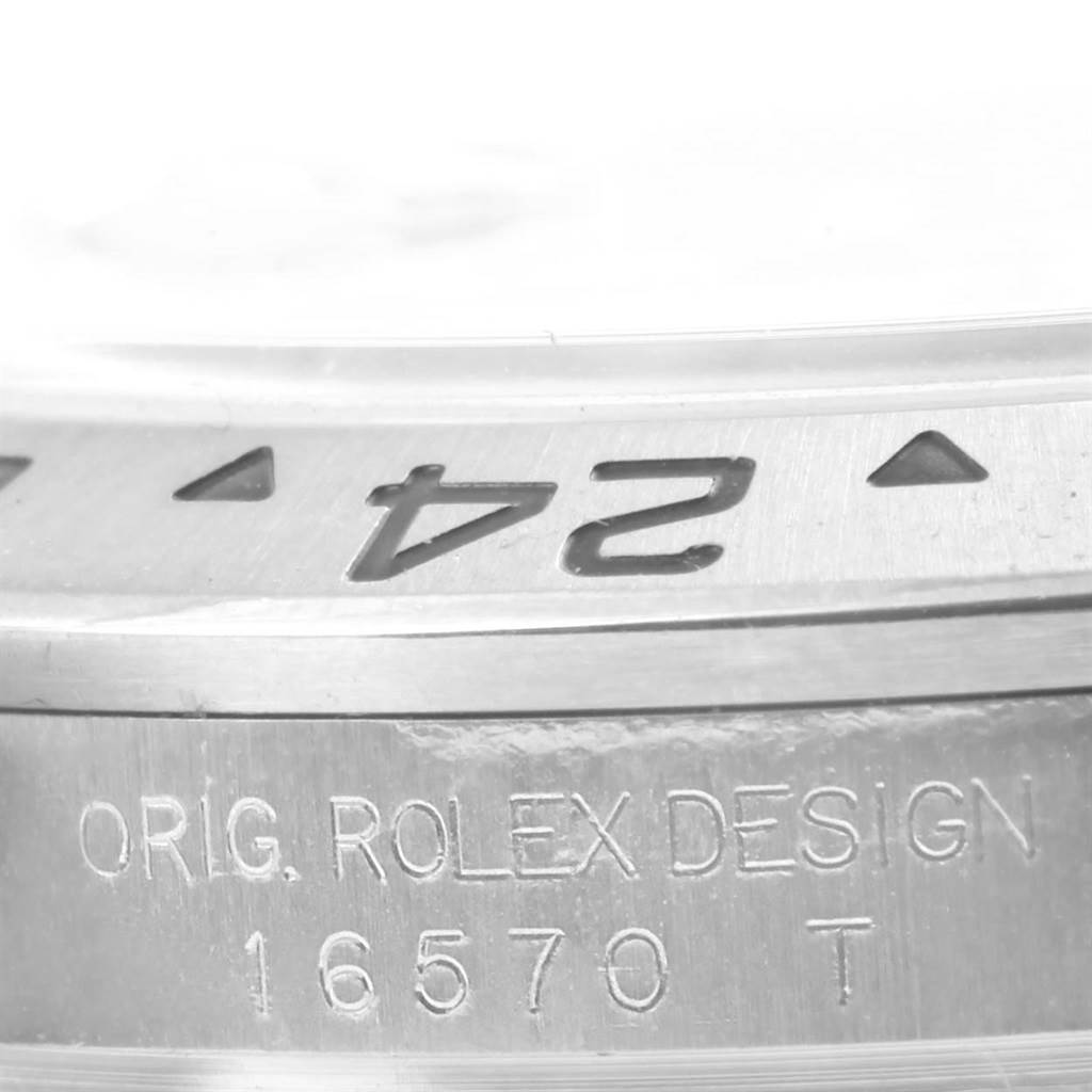 The image shows a close-up of the Rolex Explorer 16570 Men's Stainless Steel White Dial 16570 Men's Stainless Steel White Dial model's bezel and case, highlighting the "24" marking and the engraved model number "16570 T."