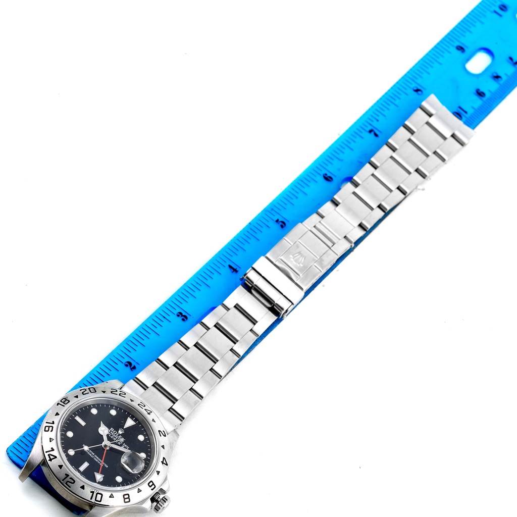 The Rolex Explorer 16570 Men's Stainless Steel Black Dial 16570 Men's Stainless Steel Black Dial watch is shown from a top-down angle, highlighting the bezel, dial, bracelet, and clasp, with a ruler alongside.