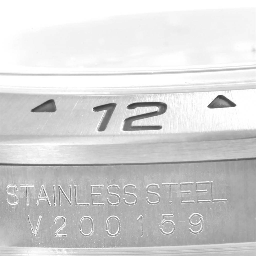 The image shows a close-up of the bezel and engraved stainless steel case of a Rolex Explorer 16570 Men's Stainless Steel White Dial 16570 Men's Stainless Steel White Dial watch.