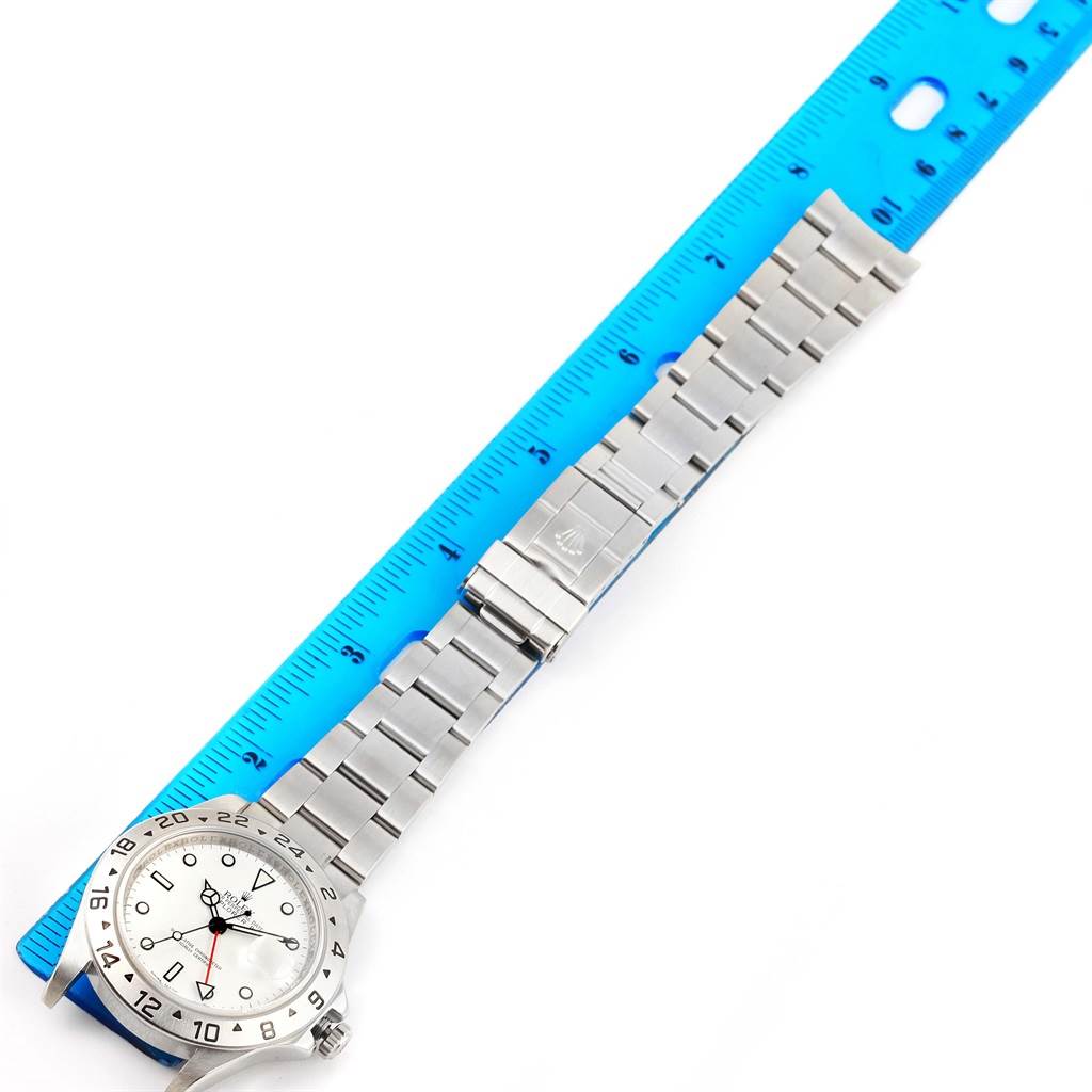 The image shows a Rolex Explorer 16570 Men's Stainless Steel White Dial 16570 Men's Stainless Steel White Dial watch laid flat, with a blue ruler beside it for scale.