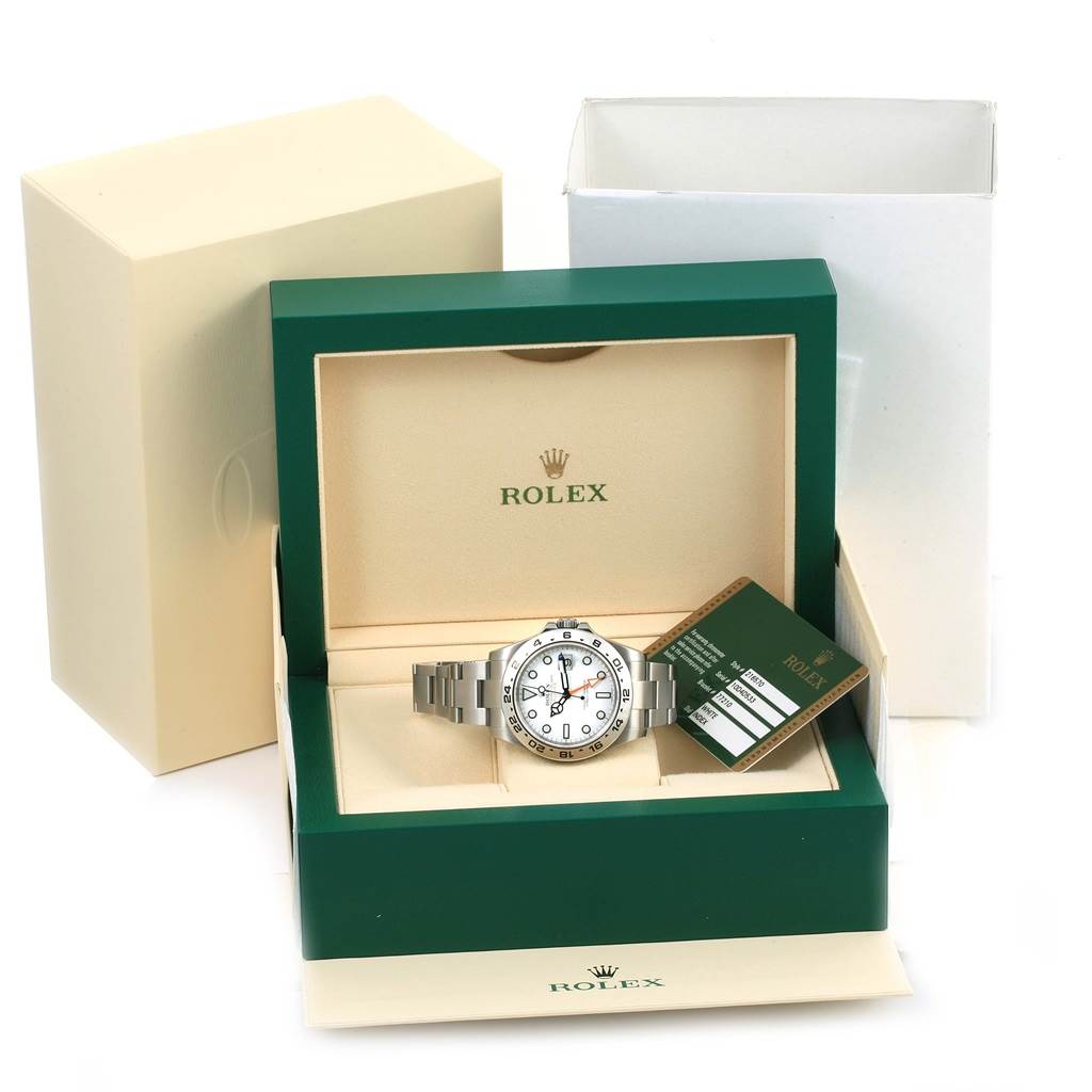 The image shows a Rolex Explorer 216570 Men
s Stainless Steel White Dial 216570 Men
s Stainless Steel White Dial watch displayed in an open green and beige Rolex box with its Best Quality
ity card.