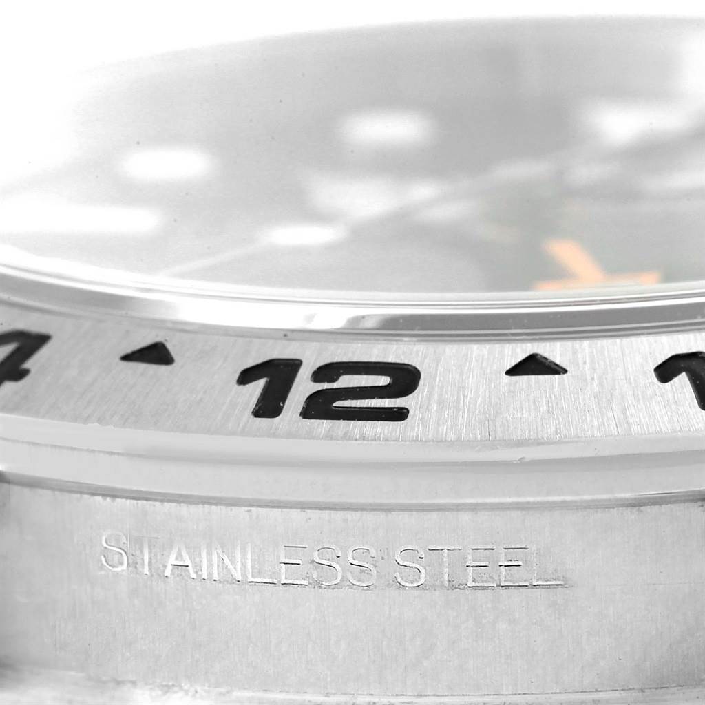This close-up image of the Rolex Explorer 216570 Men's Stainless Steel Black Dial 216570 Men's Stainless Steel Black Dial watch shows the bezel, part of the dial, and "STAINLESS STEEL" engraving on the case.