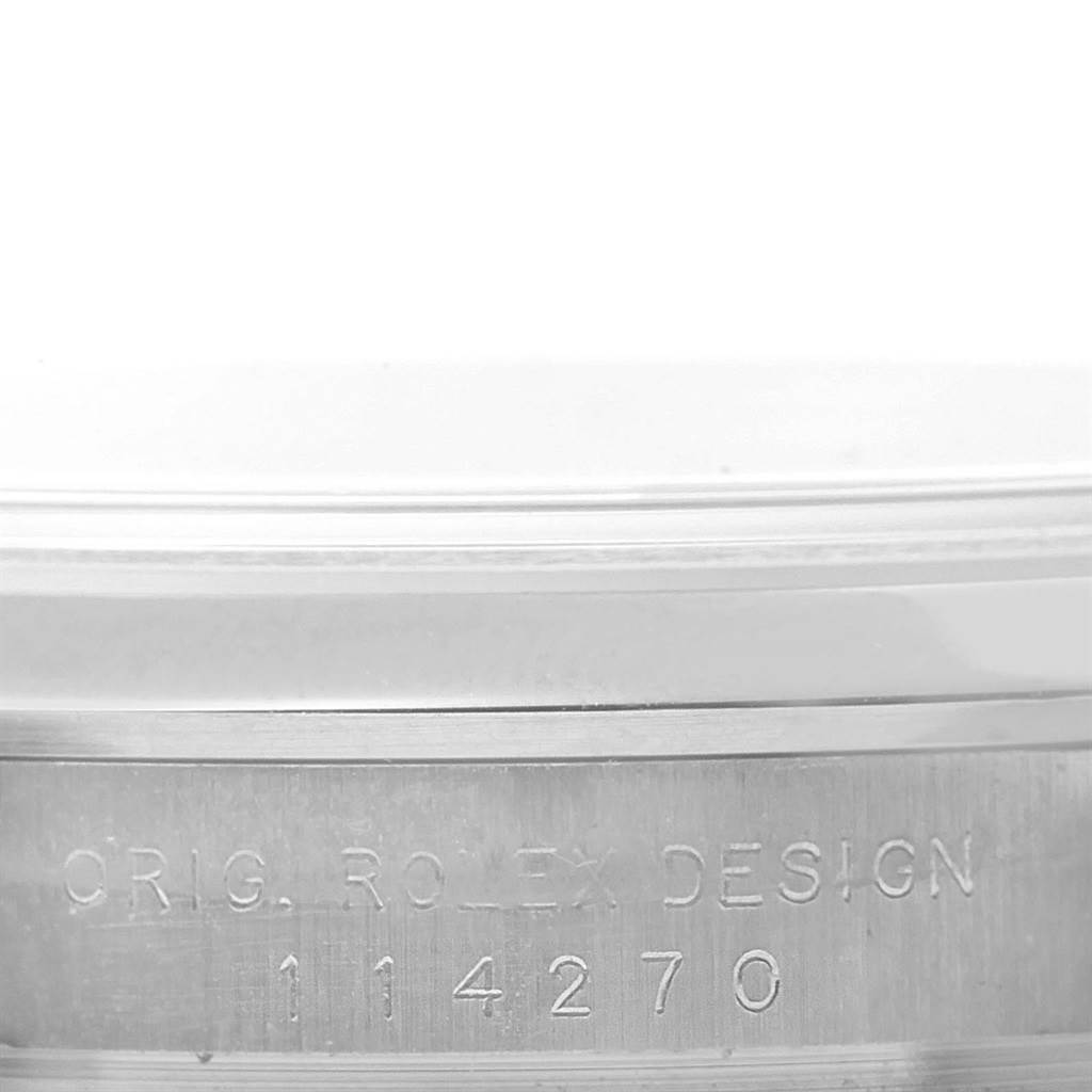 The image shows a close-up of the side of the Rolex Explorer 114270 Men's Stainless Steel Black Dial 114270 Men's Stainless Steel Black Dial model, featuring its model number and "ORIG. ROLEX DESIGN" engraving.