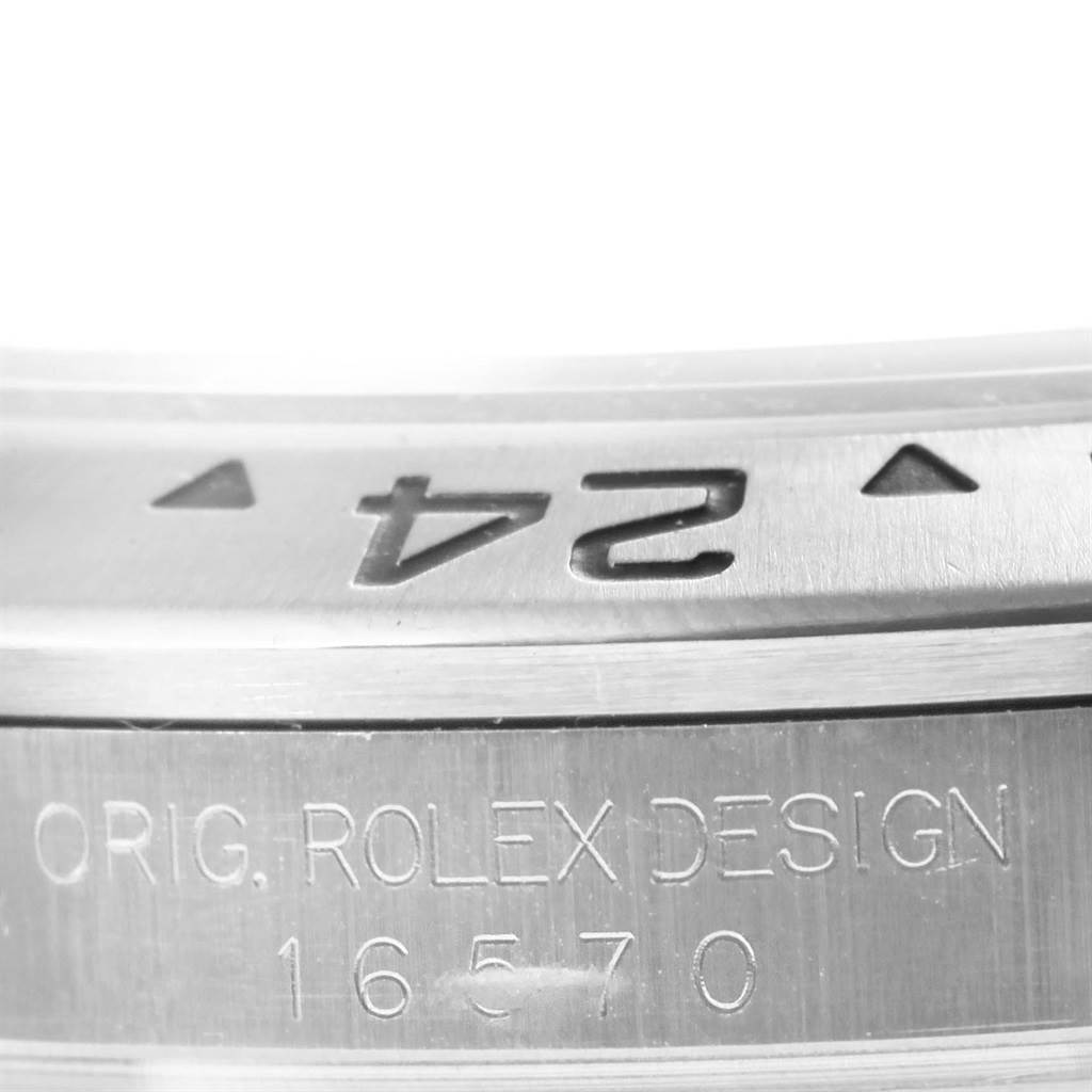 The image shows a close-up of the Rolex Explorer 16570 Men's Stainless Steel Black Dial 16570 Men's Stainless Steel Black Dial model, highlighting the engraved "24" marker and "ORIG. ROLEX DESIGN 16570" on the case.