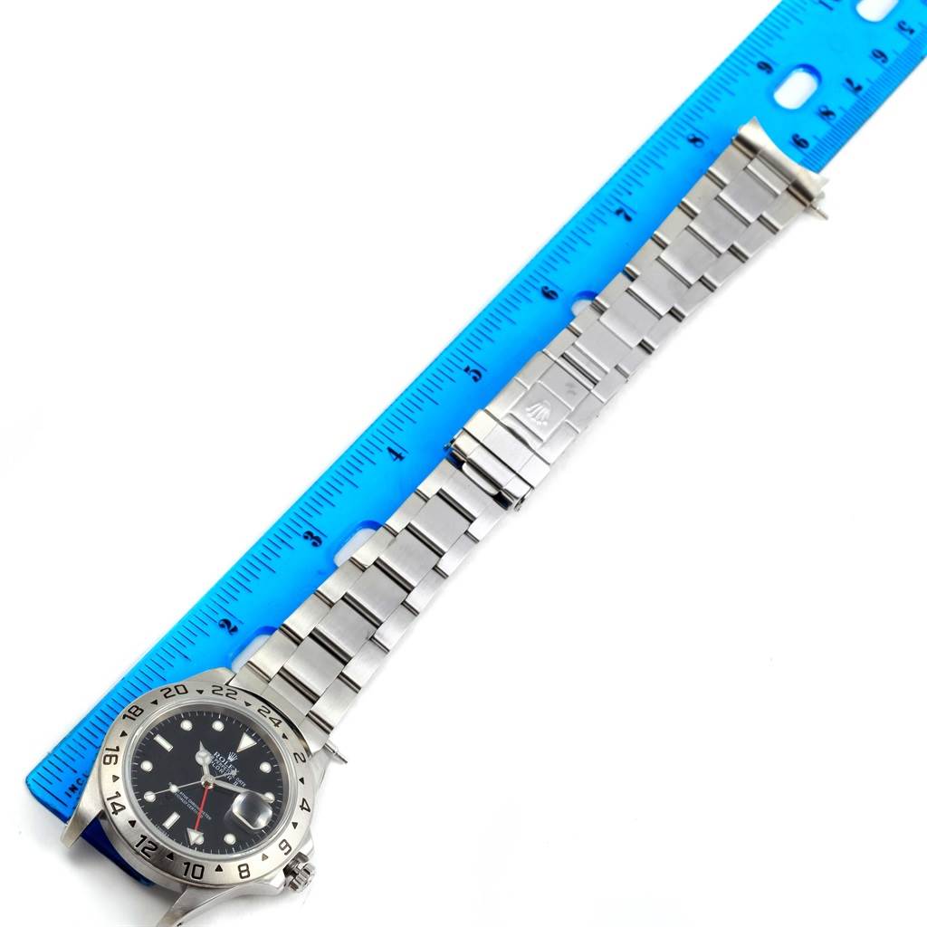 The image shows a Rolex Explorer 16570 Men's Stainless Steel Black Dial 16570 Men's Stainless Steel Black Dial watch laid flat next to a ruler, displaying the bracelet and face at an angle.