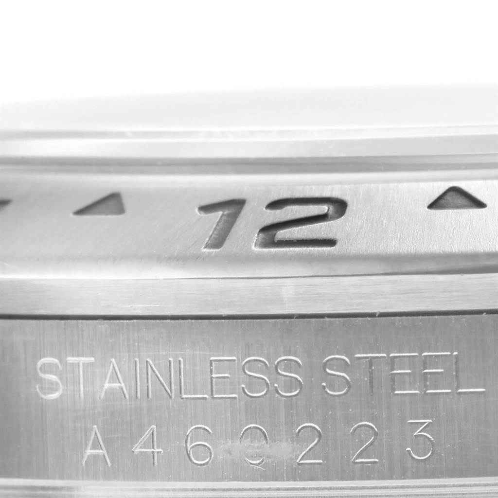 This close-up image shows the bezel engraved with a "12" and the serial number of a stainless steel Rolex Explorer 16570 Men's Stainless Steel Black Dial 16570 Men's Stainless Steel Black Dial watch.