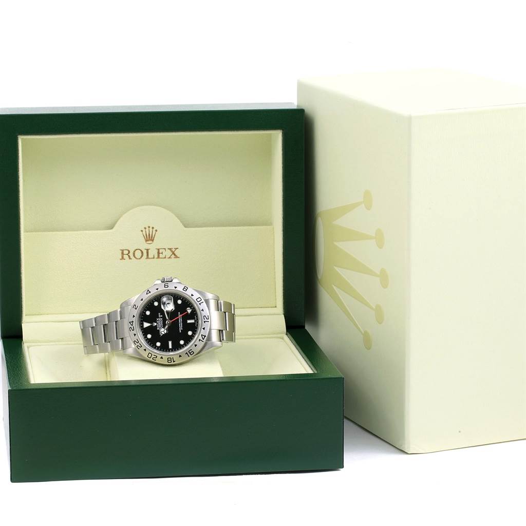 The Rolex Explorer 16570 Men's Stainless Steel Black Dial 16570 Men's Stainless Steel Black Dial watch is displayed face-up in an open green box, positioned next to its outer packaging.