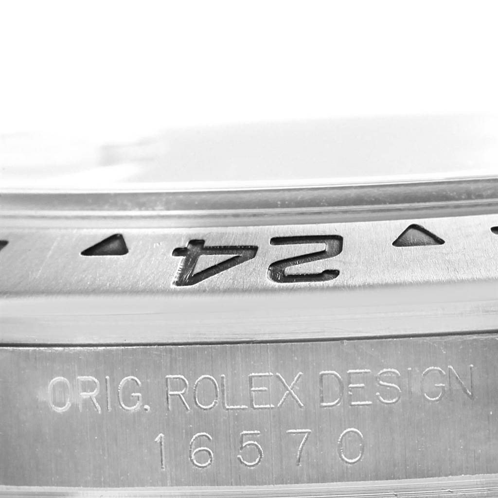 The image shows a close-up of the bezel and case of the Rolex Explorer 16570 Men's Stainless Steel White Dial 16570 Men's Stainless Steel White Dial model, highlighting the "24" marker and the case engraving.