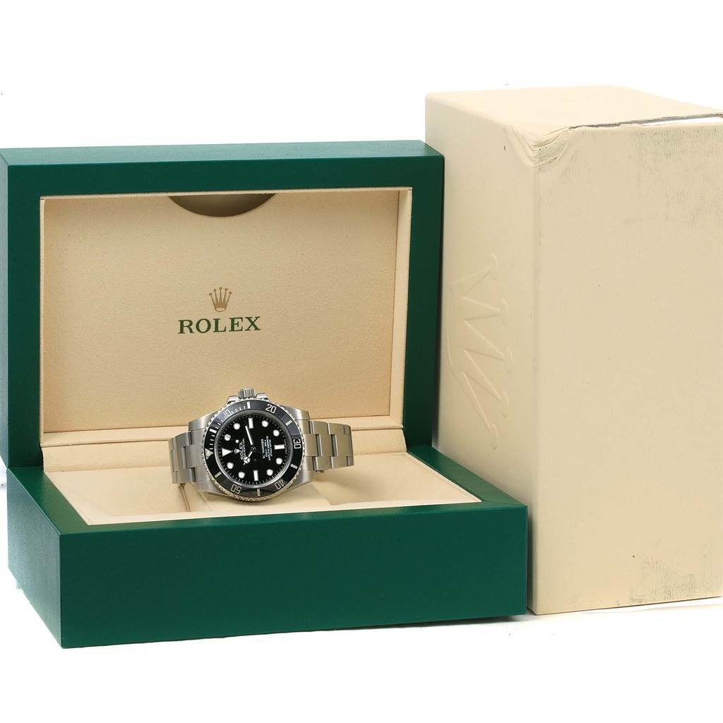 The Rolex Explorer 114060 Men's Stainless Steel Black Dial 114060 Men's Stainless Steel Black Dial watch is shown in its green box, positioned face-front with its bracelet extended.