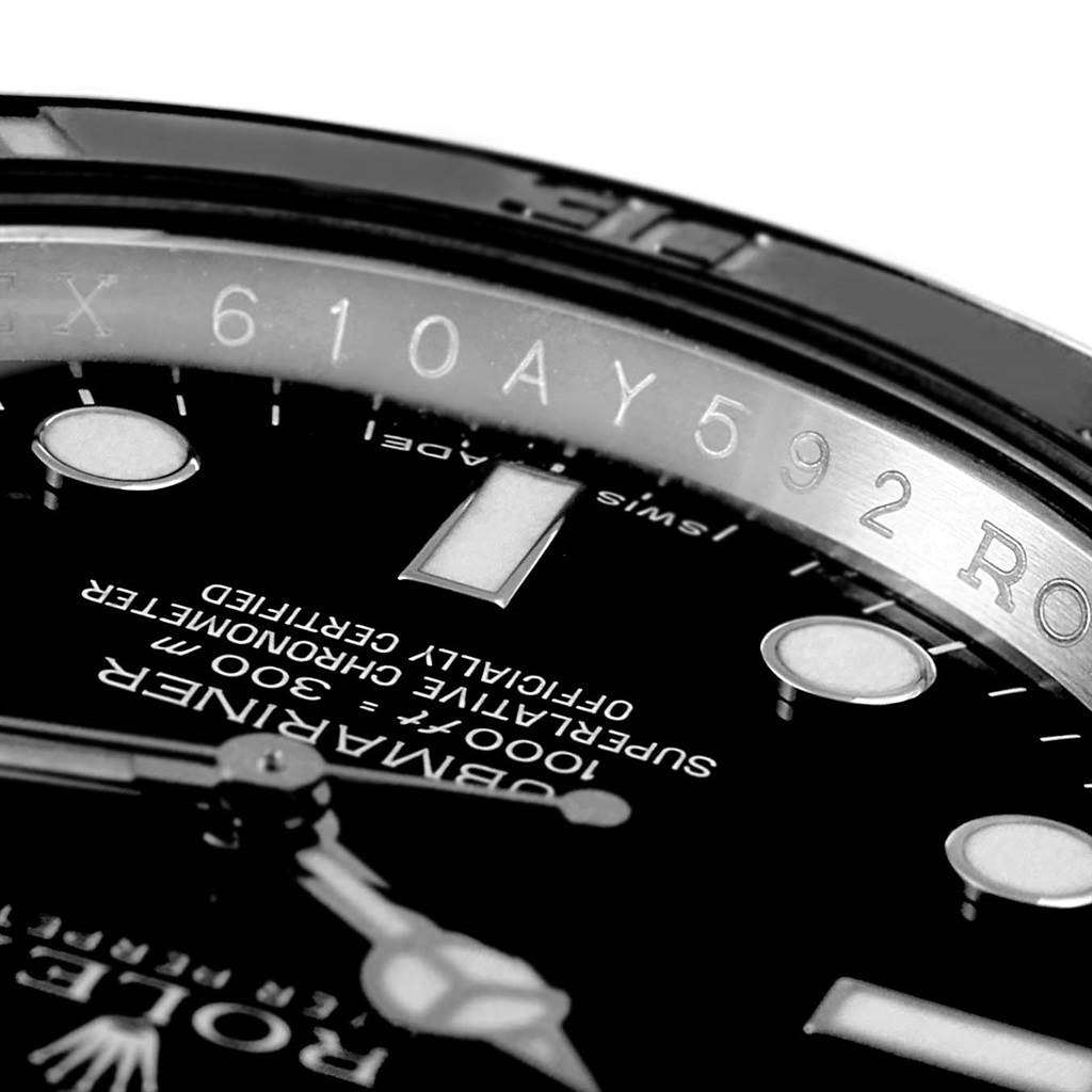 The image shows a close-up of the Rolex Explorer 114060 Men's Stainless Steel Black Dial 114060 Men's Stainless Steel Black Dial watch dial, bezel, serial number, and part of the hands.