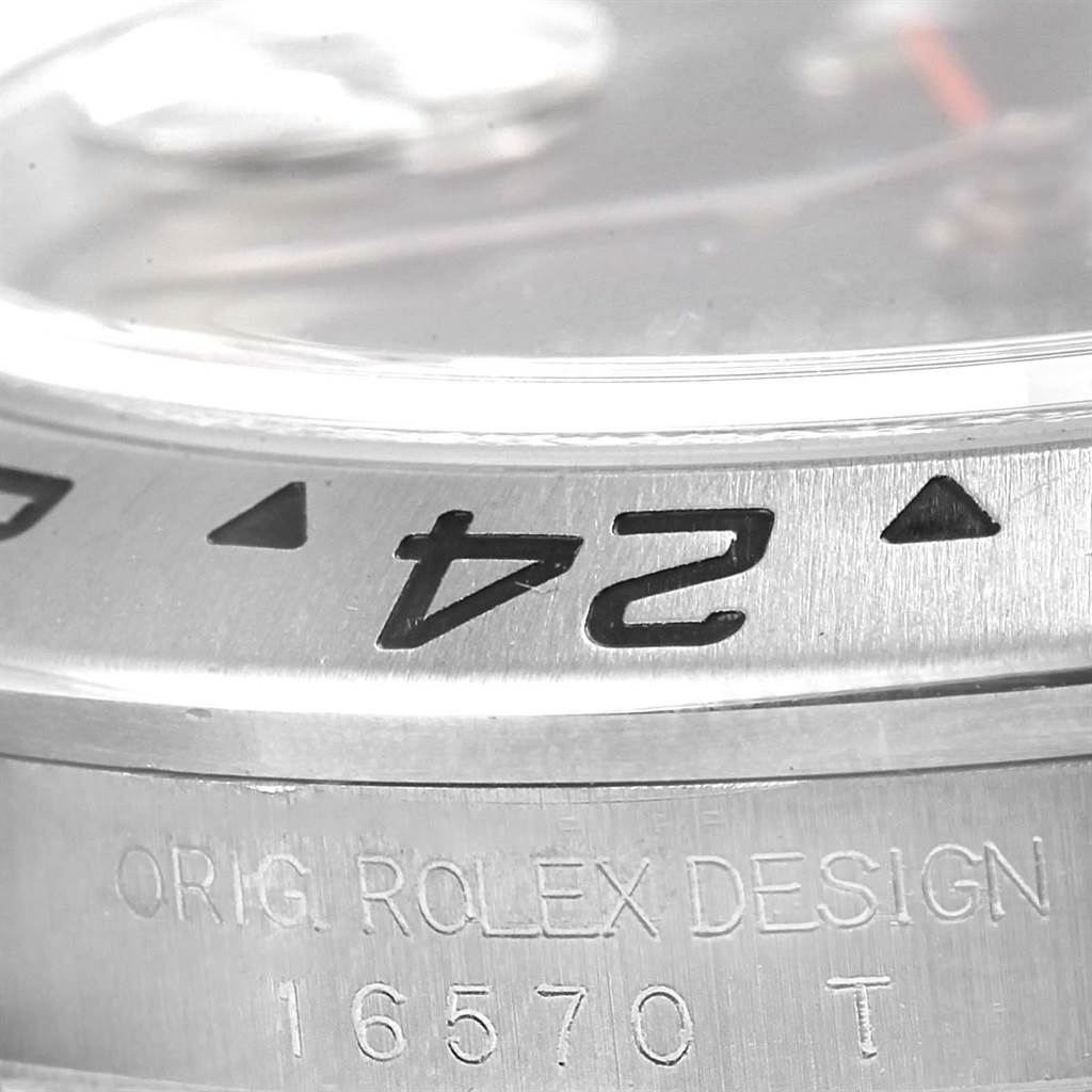 This photo shows a close-up of the bezel and case of the Rolex Explorer 16570 Men's Stainless Steel Black Dial 16570 Men's Stainless Steel Black Dial model, featuring the design inscription and model number 16570 T.