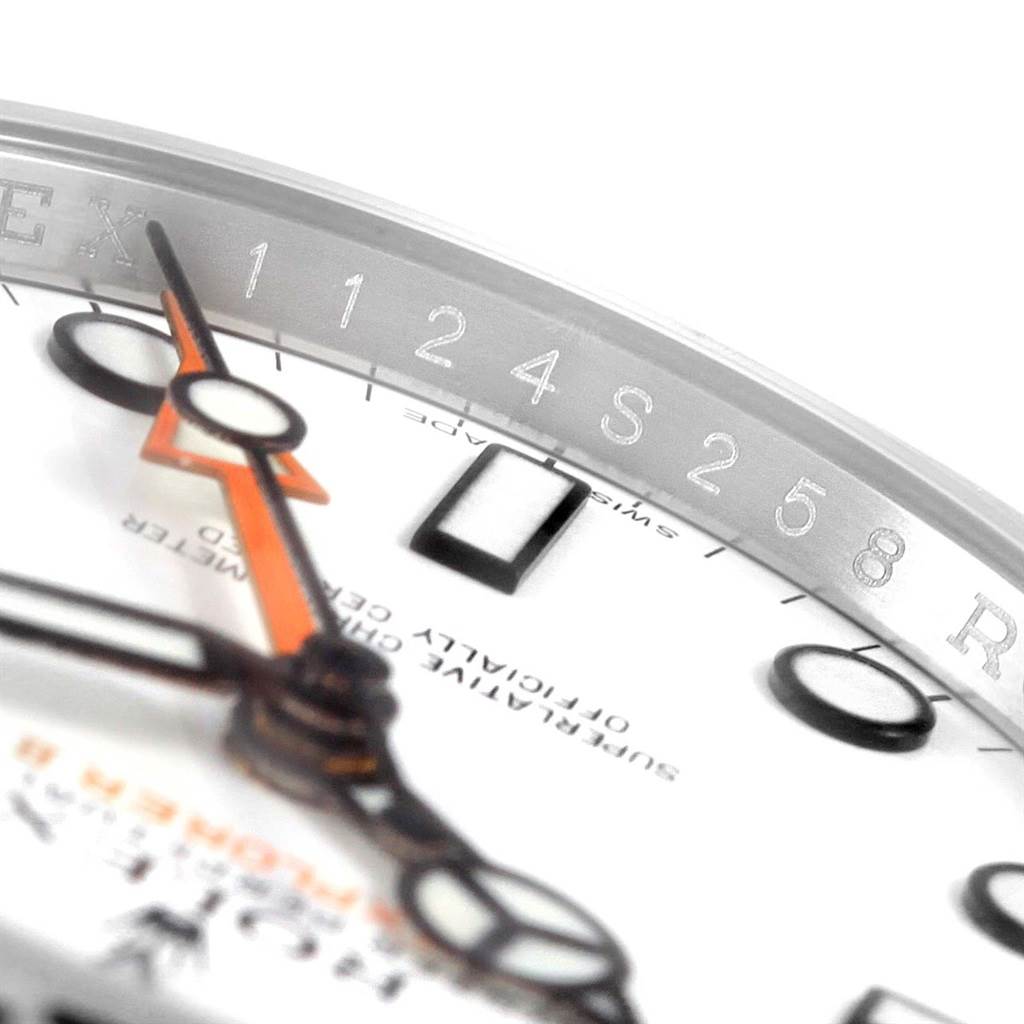 This close-up of the Rolex Explorer 216570 Men's Stainless Steel White Dial 216570 Men's Stainless Steel White Dial watch shows the hands, dial markers, and partial rehaut engraving at an angle.