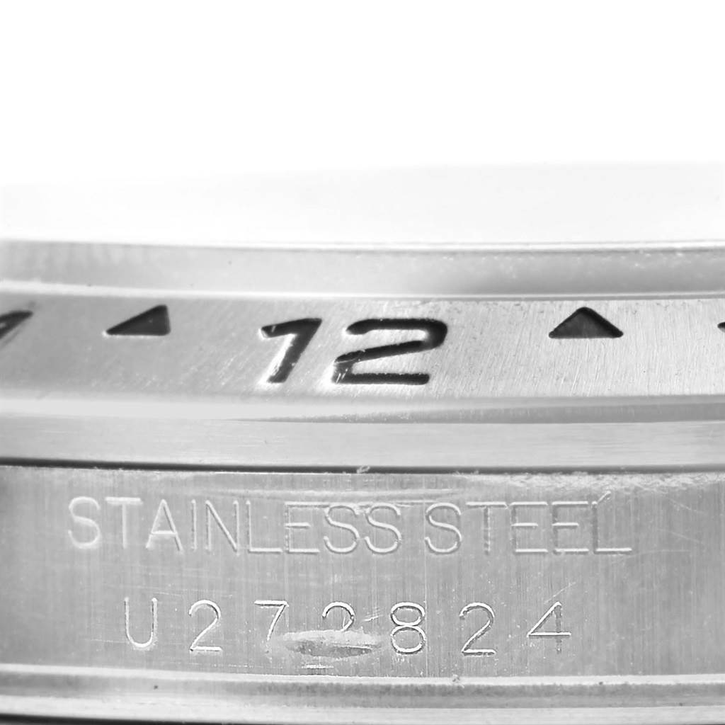 The image shows a close-up of the bezel and engraved serial number on a Rolex Explorer 16570 Men's Stainless Steel White Dial 16570 Men's Stainless Steel White Dial watch made of stainless steel.