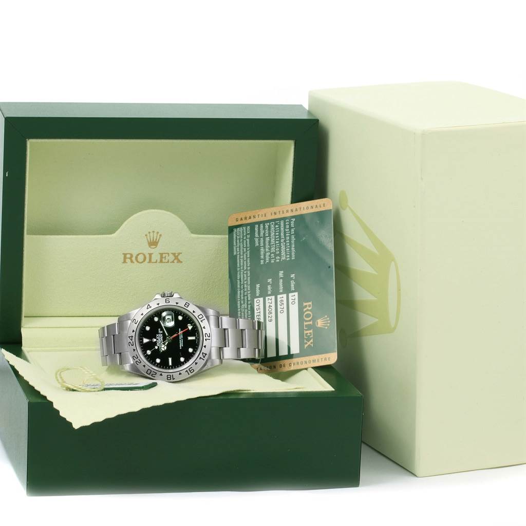 The image shows a Rolex Explorer 16570 Men's Stainless Steel Black Dial 16570 Men's Stainless Steel Black Dial watch positioned in its open box, alongside the warranty card, set at an angle so the watch face and bracelet are visible.