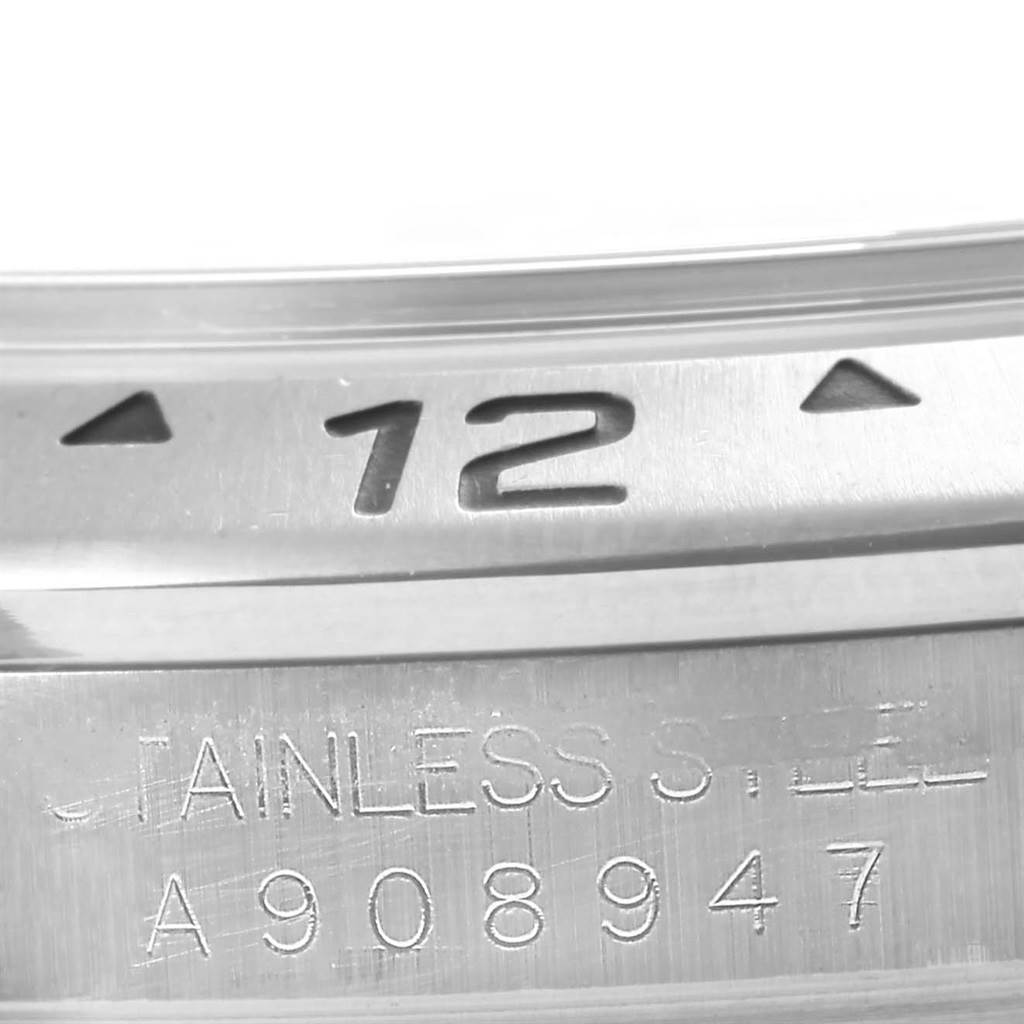 This image shows a close-up of the stainless steel bezel and engraved serial number of a Rolex Explorer 16570 Men's Stainless Steel Black Dial 16570 Men's Stainless Steel Black Dial watch.