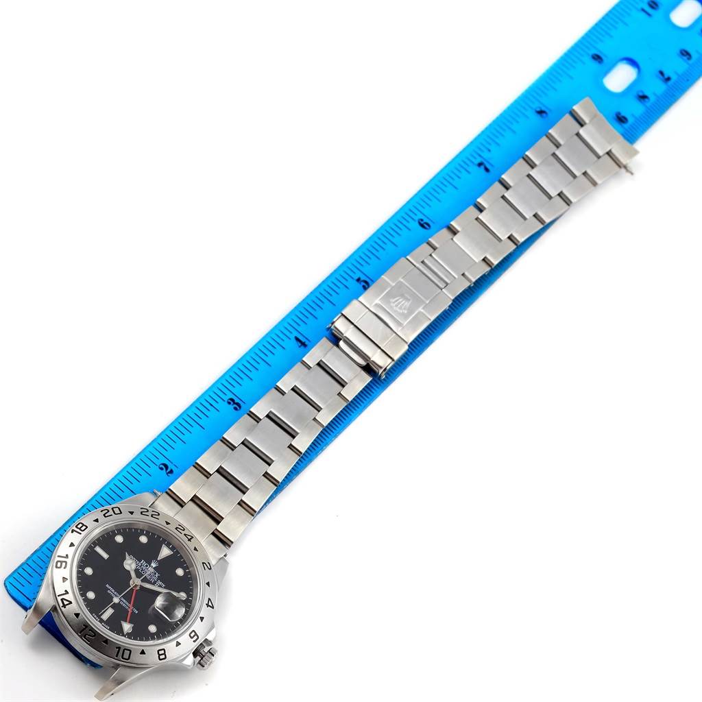 The image shows a Rolex Explorer 16570 Men's Stainless Steel Black Dial 16570 Men's Stainless Steel Black Dial watch laid flat, showcasing its metal bracelet and face beside a blue ruler for scale.