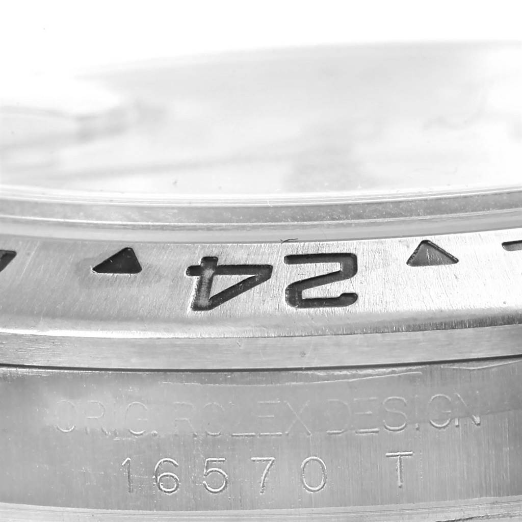 This close-up image shows the bezel and part of the casing of a Rolex Explorer 16570 Men's Stainless Steel White Dial 16570 Men's Stainless Steel White Dial watch, including model number 16570 T.